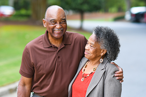 African American couple standing outside smiling in an embrace